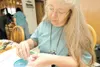 ROBERT DeBERRY/Frontiersman Jeanette Shanigan joins two small
canvas squares together that will become part of a larger quilt
made of beads. In 2004, Shanigan started ‘Bead-It-Forward’ in hop