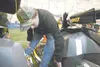 ROBERT DeBERRY/Frontiersman Wounded Warrior Project team member
Charlie Potter applies a Tesoro Iron Dog Race sponsor sticker to
his new Ski-Doo snowmachine. For Potter, the race is not about