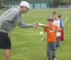 Mat-Su outfielder Connor Wanhanen helps a young player during the Miners annual summer kids baseball clinic at Hermon Brothers Field. Courtesy of Sienna Best