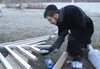 Rabbi Mendy Greenberg screws a lightbulb into a modern menorah for display at Wasilla Lake on Thursday morning, Dec. 3. The menorah will be temporarily relocated to the Palmer Depot on Wednes