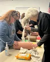 Instructor Brenda McCain shows a student how to properly pack a wound on the wound simulator. Courtesy photo