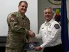 JOINT BASE ELMENDORF-RICHARDSON, Alaska -- Ted Stevens Anchorage International Airport Fire Department Lt. Daniel Juarez presents Alaska Air National Guard Master Sgt. Jason Hughes, a 212th R
