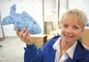 Yvonne Marty holds a fish she designed from a plastic bottle. Marty has taken on the task of making decorations from recycled materials for the Palmer High School senior prom in hopes that th