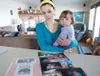 Jessica Smith and her daughter Violet Plummer stand in front of a group of photos of Smith's fiancée Michael Plummer. Plummer was killed Wednesday evening when three men burst into the house 
