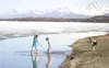 GREG JOHNSON/Frontiersman Nine-year-old Madison Hooks, left,
Nathan Hooks, 7, center, and 8-year-old Kallysta Hull cool off in
the water near the shore of Wasilla Lake on Saturday. Although
t