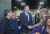 Gov. Mike Dunleavy, standing at the entrance of the Alaska Federation of Natives convention arts and crafts fair last month, shakes the hand of a convention attendee. In votes counted through