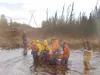 Courtesy photo/Houston Fire Department Rescue workers carry an
elderly woman to safety after she fell into a creek at about Mile 1
Big Lake Road.