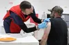 Dan Foster receives the COVID-19 vaccine as Craig Dollerhide administers the shot at Raven Hall on Tuesday.  Tim Rockey/Frontiersman