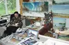 CASEY RESSLER/Frontiersman Curt Wagner relaxes in his Talkeetna
studio, as a painting of the aurora borealis waits to be completed.
Entering Wagner's studio is like taking a step back in time