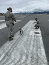 U.S. Air Force Airmen 1st Class Hannah Klein and Leandra Ventura-Perez, 3rd Operations Support Squadron Airfield Management shift lead and operations coordinator, assess airfield pavement dam