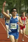 Eric Engman/News-Miner Palmer's Jake Parisien raises his hand in
victory after winning a hard-run duel with Kodiak's Trevor Dunbar,
back left, in the boys 4A 3,200 meter event during the 2008