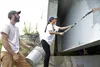 Derrick Holland and Amber Moffit work to paint over graffiti on the George Palmer Bridge Sunday. photos by Anthony Jones/For the Frontiersman