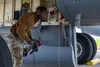 U.S. Air Force Staff Sgt. Eddy Odongpinyokene, 909th Aircraft Maintenance Unit flying crew chief, carries a fuel hose underneath a 909th Air Refueling Squadron KC-135 Stratotanker during the 