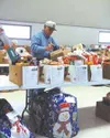 Volunteer Ed Kern prepares Christmas baskets at the Palmer
Depot. The Palmer Food Bank put together the baskets, including
food for dinner and Christmas presents. BARBARA HUNT/For the
Frontie