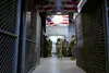 Chief Master Sgt. of the Air Force JoAnne S. Bass surveys the equipment lockers of combat rescue officers and pararescuemen (PJs) at the 212th Rescue Squadron facility at Joint Base Elmendorf