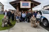 Members of the United Service Organizations West Region Advisory Board pose with Military Working Dog handlers assigned to the 673d Security Forces Squadron during a base tour at Joint Base E