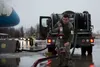 U.S. Air Force Senior Airman Aaron Dobizl, 673d Logistics Readiness Squadron, carries a fuel line while preparing to refuel Air Force Two while Vice President of the United States Mike Pence 