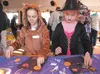 Paige Buckalew, 8, as a fox, and Jenna Hamm, 7, as a witch, decorate their trick-or-treat bags at the Wasilla Old Town Autumn Fest Saturday afternoon. ROBERT DeBERRY/Frontiersman.com