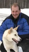 Rookie musher and airline pilot Phil Morgan holds onto his lead
dog, Ardie before he gets screened at the ITC veterinarian booth
Monday at Iditarod headquarters. GENE JANSEN/Frontiersman