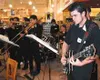 John Hartman plays the guitar while the brass and percussion
sections of Just Playin' Jazz play during a private Fred Meyer
opening event Tuesday night. Photo by STEVE KADEL/Frontiersman.