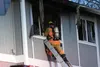 A Central Mat-Su Fire Department firefighter looks into a second-story window at a four-plex apartment complex that caught fire on Sunday, Jan. 3, 2016. No one was hurt in the fire, which was