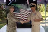 U.S. Air Force Col. Lisa Mabbutt, commander of Joint Base Elmendorf-Richardson and the 673d Air Base Wing, stands in front of a 3D Industrial Art USA flag with retired U.S. Navy Chief Petty O