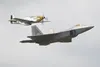 A vintage P-51 Mustang flies alongside a U.S. Air Force F-22 Raptor during a heritage flight for the Arctic Thunder Special Needs and Family Day at Joint Base Elmendorf-Richardson, Alaska on 