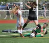 Colony goalkeeper Maddy Zmuda slides underneath teammate Ripley Wakaliuk as she tries to keep the ball away from Wasilla's Jodie Richey during a 2-1 loss to the Warriors in the consolation se
