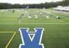 Members of the Palmer High School varsity football squad stretch before practice on the new artificial field turf at Machetanz Field Thursday afternoon. The Moose will play their first game o