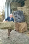 VICKI NAEGELE/For the Frontiersman — Country Garden Farms' Becky
Sorensen of Palmer carries a "square" bale of grass hay to a
customer's trailer. Country Garden Farms sold everything from its
