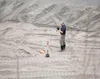 Mat-Su Borough code compliance officer Mark Whisenhunt takes pictures after digging a series of test holes Thursday in a gravel pit near Mile 38, Glenn Highway. ROBERT DeBERRY/Frontiersman.co
