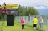 Jeff Smith with DG Signs puts the finishing touches on a new sign at Cottonwood Creek Elementary School in Wasilla Friday. Principal Lisa Vrvilo, in pink, said the school worked for the past 