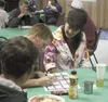 A pair of Mat-Su Miners sign a team program for team supporter Linda Jo Klapperich during the Miners pancake breakfast at the Palmer Moose Lodge Saturday morning. TIM ROCKEY/Frontiersman