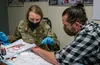 U.S. Air Force Col. Kirsten Aguilar, Joint Base Elmendorf-Richardson and 673d Air Base Wing commander, applies moulage to Darren Vandeursen, a 673d Medical Support Squadron education and trai
