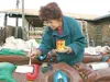 Above, Alaskan artist Gail Schuster does some touch-up painting
on the lips of a beaver on one of the two 25 foot totem poles
commissioned by Valdez businessman Larry Reynolds Monday afternoo