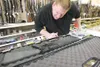 ROBERT DeBERRY/Frontiersman Chimo Guns sales associate Craig
Pell checks the serial number on an AR-15 assult style rifle Friday
afternoon. Guns sales at Chimo Guns have increased since Tuesd