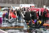 Julian Perry, left, dressed as a combination of Superman and the Joker, and Adam Fogelman, right, dressed as Batman, perform a simultaneous flip before splashing down into the ice-cold waters