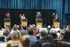 Gubernatorial candidates at an Anchorage debate on Tuesday use signs to indicate their votes on a ballot measure about a new constitutional convention. Opposing the idea of a convention to re