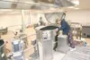 ROBERT DeBERRY/Frontiersman Nutrition services cook Judy
Cornelison peeks into one of two new 200-gallon steam kettles at
the new Nutrition Services Facility in Palmer. Construction of the
ne