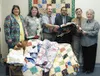Acting director for State of Alaska Division of Family and Youth
Services, Tom Cherian, shown here third from the right, was on hand
to receive quilts dedicated to DFYS by Valley CASA Program