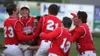 A group of Wasilla Warriors surround senior Balas Buckmaster after Buckmaster drove in the game-clinching run during a 15-5 win over rival Colony in the Southcentral Conference Championships 