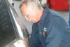 GREG JOHNSON/Frontiersman Lee McCarroll performs a brake
inspection on a used car someone brought into Mr. Lube prior to
purchasing.