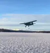 Esther Sanderlin flying her Stinson plane, named 'Stealth' doing a turkey drop over Hewitt Lake during Thanksgiving. She and a group of volunteers dropped over 30 turkeys to people in Skwentn