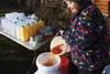 Marian Elliott pours fresh-pressed apple juice through a strainer at her Wasilla home Saturday afternoon. CAITLIN SKVORC/Frontiersman.com