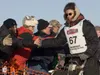 Last musher out Iditarod veteran Ryan Redington slaps hands with spectators as he heads down the starting chute at the start of the 40th running of the Iditarod Trail Sled Dog Race Sunday in 
