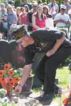 A crowd at Aurora Cemetery in Wasilla watches as JR Hackett, Veterans of Foreign Wars’ Senior Vice Commander, Department of Alaska places flowers on the grave of Vietnam Veteran Clearance E. 