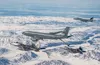 A KC-135 Stratotanker from the 168th Air Refueling Wing refuels F-22 Raptors from the 3rd Wing over the Joint Pacific Alaska Range Complex flying along side with an F-15 Eagles from the 144th