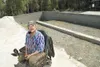 Jim White sits in front of the new foundation for his home
Monday afternoon. (ROBERT DeBERRY/Frontiersman)