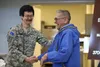 Alaska State Defense Force Sgt. John Foster, the noncommissioned officer in charge of the ASDF Quinhagak detachment congratulates retired Alaska Army National Guard Maj. Robert Hoffman during