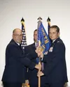 Alaska Air National Guard Col. Joshua Armstrong, incoming 176th Wing commander, accepts the unit guidon from Brig. Gen. Brian Kile during a Sept. 26, 2024, change-of-command ceremony at Joint